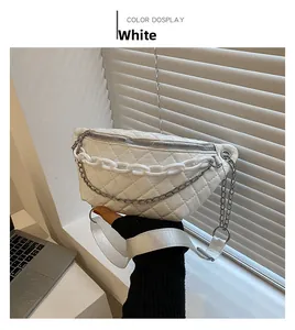 Close-up of white quilted fanny pack with chunky chains and silver zipper details