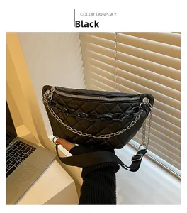 Detailed view of a black quilted waist bag with chunky chain and metallic hardware