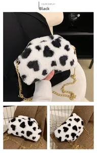 Dettaglio della borsa a tracolla in peluche con motivi a cuore neri e bianchi e catena d'oro