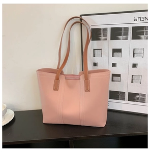 Pink minimalist tote bag with brown double straps displayed in a modern home interior