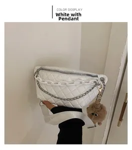 Detail of white quilted belt bag with chunky chain and brown plush bear charm
