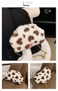 Dettagli di una borsa in peluche bianca con motivi a cuore marroni e catena dorata