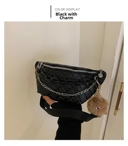 Detail of black quilted leather waist bag featuring gold chain and fuzzy charm