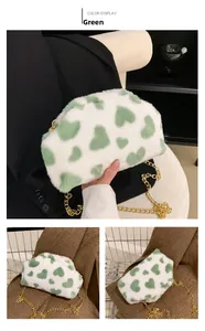 Dettaglio della borsa in peluche verde e bianca con motivo a cuori e catena metallica oro