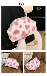 Dettaglio della borsa in peluche bianca con cuore rosa e tracolla a catena d'oro