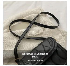 Detail shot of black quilted shoulder bag featuring an adjustable strap and embossed texture