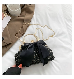 Detail of black tweed crossbody bag with large satin bow and vintage metal handle
