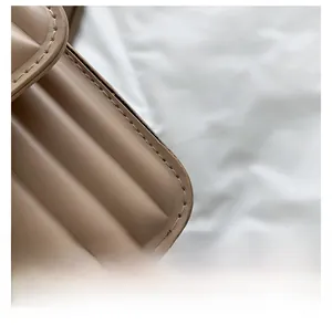 Detailaufnahme der gesteppten beigen Ledertasche mit feinen Nähten und runden Kanten