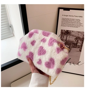 Dettaglio borsa in ecopelliccia bianca con cuori viola e catena dorata