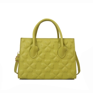 Retro bright green handbag with embossed clover patterns and adjustable shoulder strap