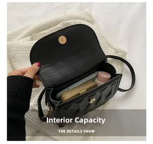 Internal view of black quilted crossbody bag showing capacity for phone and wallet