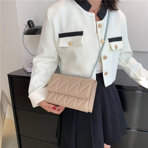 Chic beige quilted crossbody bag with silver chain strap shown in an elegant lifestyle setting