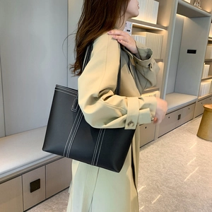 Minimalist black tote bag with white contrast stitching for daily commute