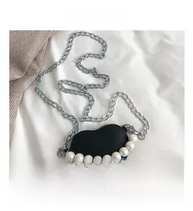 Détail du mini sac en forme de cœur avec grosses perles et bandoulière chaîne argentée