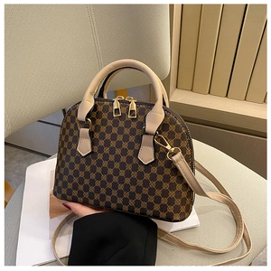 Detail of vintage dome bag with geometric pattern, beige leather handle and gold hardware