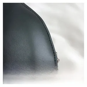Détail de la texture en similicuir noir avec coutures précises et fermeture éclair argentée