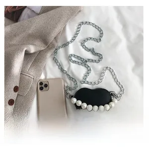 Détail du sac cœur en cuir avec de grosses perles blanches et une chaîne en argent