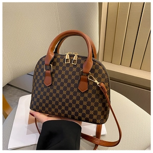 Detail of vintage shell bag showing geometric pattern and brown leather straps