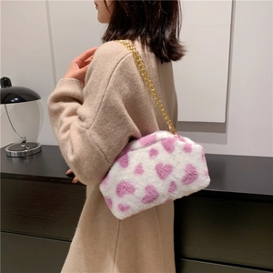 Borsa a tracolla in peluche con motivo a cuore e catena dorata indossata da modella