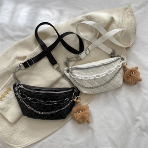 Quilted waist bags in black and white with metal chains and bear pendant decor