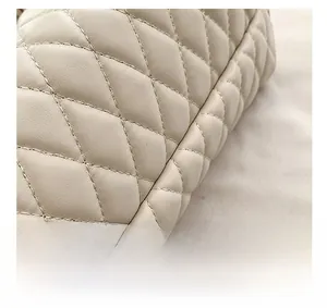 Detailed close-up of premium quilted cream leather with precise diamond stitching texture