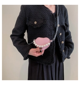 Détail du sac bandoulière rose en forme de cœur avec poignée en perles et chaîne argent