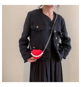 Gros plan du sac cœur en cuir rouge avec bandoulière en perles et détails argentés