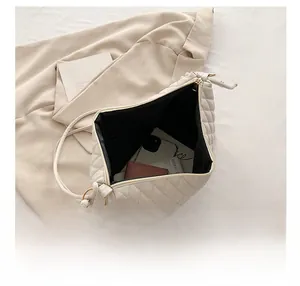 Top view of spacious interior of a beige quilted bucket bag showing daily essentials