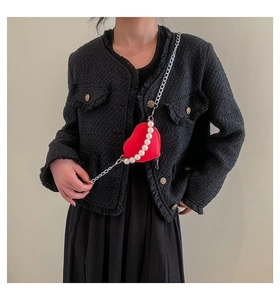 Détail du mini sac rouge en forme de cœur avec chaîne en perles et bandoulière argent