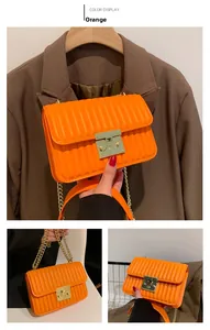 Detail der orangefarbenen gesteppten PU-Ledertasche mit vertikaler Textur und Goldschloss