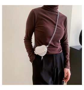 Détail du sac à bandoulière coeur en cuir blanc avec perles et bandoulière chaîne