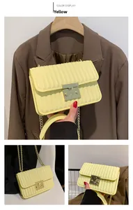 Detailansicht der gelben gesteppten Umhängetasche mit Goldkette und quadratischem Verschluss