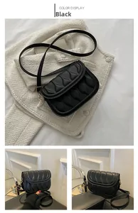 Detail view of black quilted shoulder bag with cloud texture and gold magnetic buckle