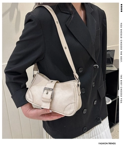 Creamy white matte texture underarm bag with silver buckle and quilted details on model