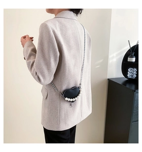 Détail du mini sac cœur en cuir noir avec décor perlé et bandoulière chaîne argentée