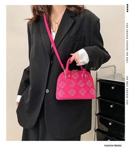 Détail du mini sac coquille rose fuchsia avec motifs floraux rivetés et zip doré