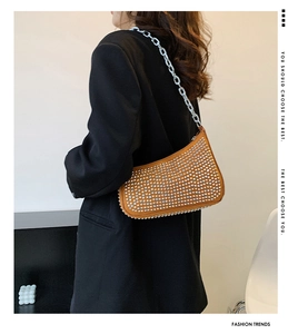 Close-up of brown rivet shoulder bag with silver studs and chunky metal chain strap