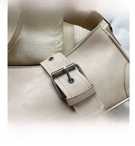 Detail shot of beige shoulder bag showing the buckle strap and premium faux leather texture