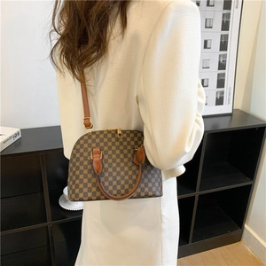 Classic brown monogram shell bag with caramel handles shown in a modern interior setting