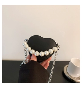 Détail du mini sac cœur noir avec poignée en perles blanches et bandoulière en chaîne