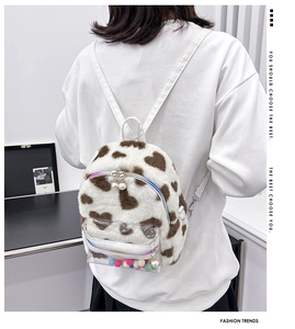 Détail du mini sac à dos en peluche blanche à taches de cœur et poche avant transparente