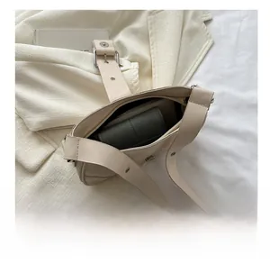 Top view of beige leather bag interior showing capacity with a long dark green wallet