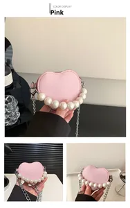 Vue détaillée du mini sac rose en forme de cœur avec poignée perlée et chaîne argent