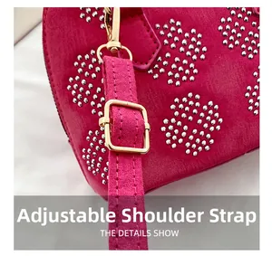 Détail de la bandoulière réglable avec garnitures dorées sur le sac en daim rose