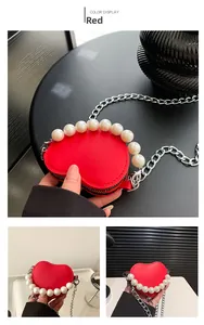 Vue détaillée du mini sac cœur rouge avec poignée en perles et fine chaîne métallique