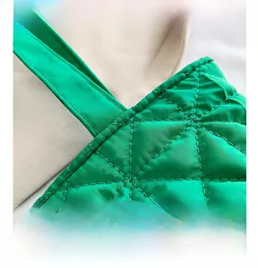 Detailed macro view of green quilted nylon tote bag with fine diamond stitching finish