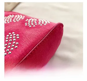 Détails de sac en daim rose fuchsia avec rivets en forme de cœur et coutures précises