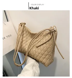 Detail view of khaki quilted bucket bag with elegant diamond stitching and gold metal accents