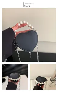 Détail du mini sac cœur noir avec poignée en perles et bandoulière chaîne