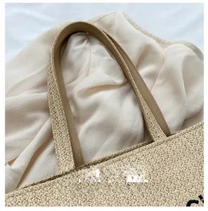 Detail of premium leather handle and woven straw texture on large tote bag
